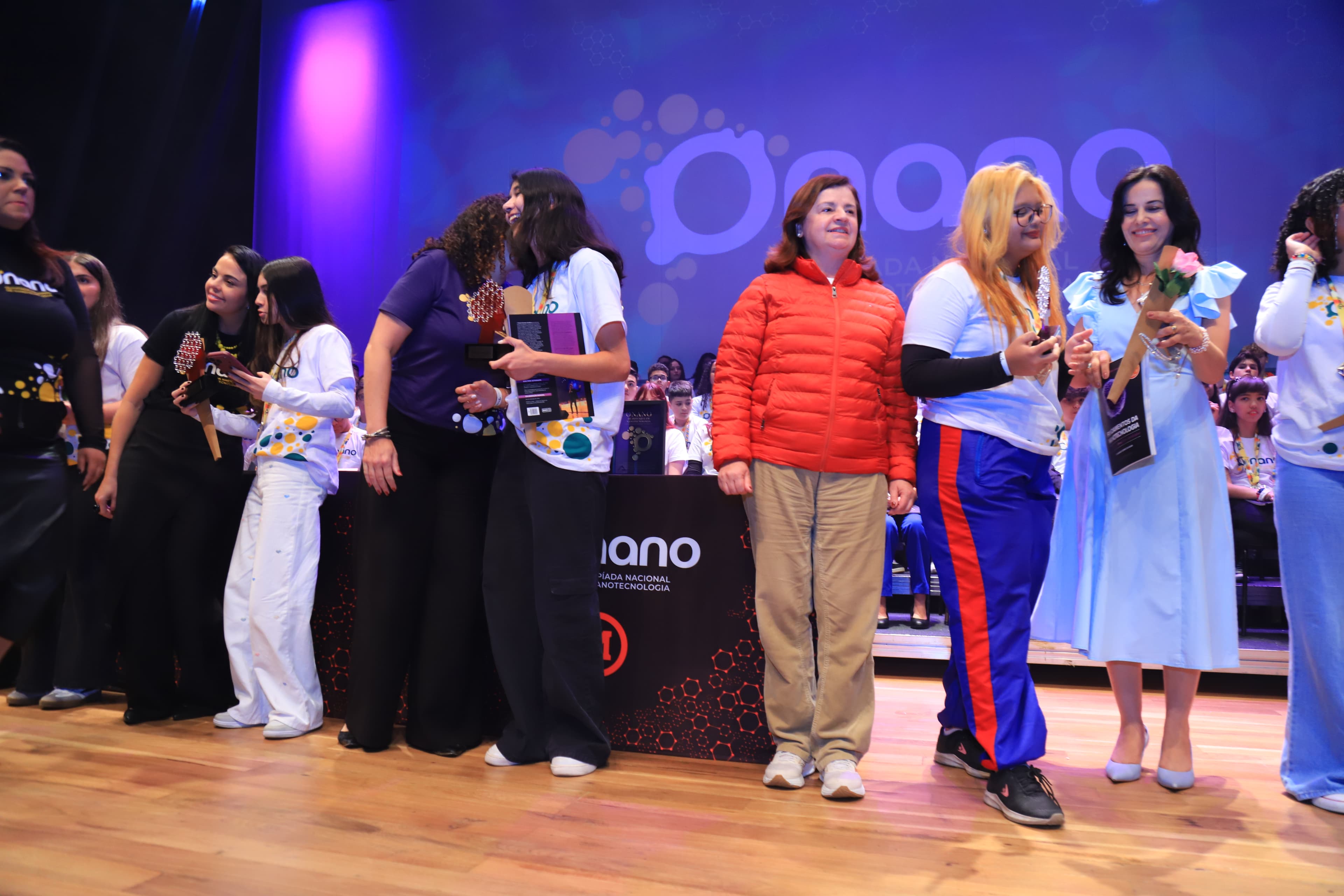 Medalhistas recebendo prêmios no palco da premiação da ONANO